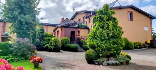 a house with a tree in front of a yard at Dom Pod Gruszą in Chmielno