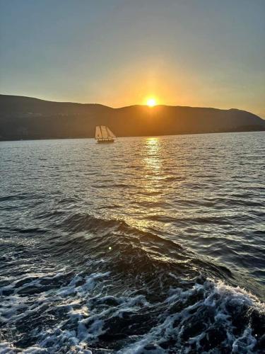un bateau sur une grande étendue d'eau au coucher du soleil dans l'établissement Apartment Steven, à Herceg-Novi