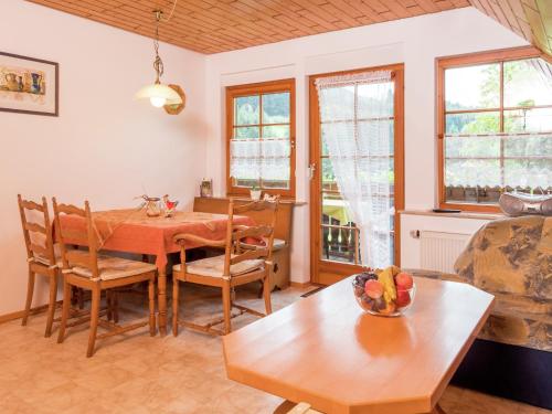 a dining room with a table and chairs and windows at Gemütliche Ferienwohnung im Schwarzwald in Fohren