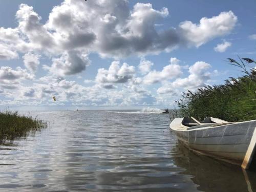a boat sitting on the water near the shore at 6 person holiday home in Ringkøbing in Ringkøbing