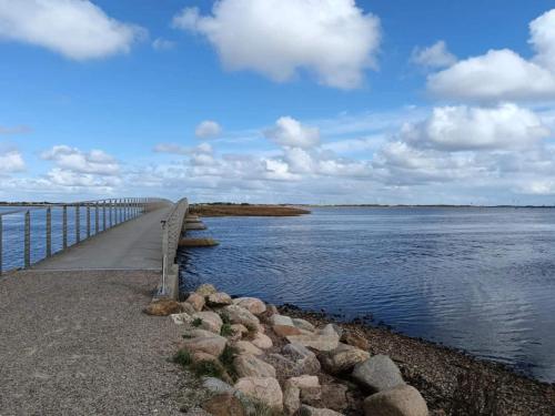 a bridge over a body of water with rocks at 6 person holiday home in Ringkøbing in Ringkøbing