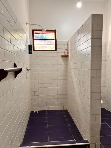 a bathroom with white tile walls and a window at Honeydream Villa & Studio Apartments in Diani Beach