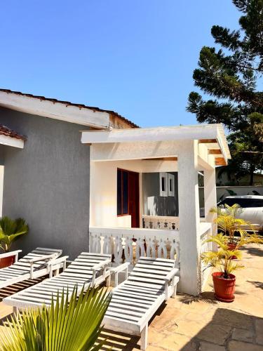 a group of white benches in front of a building at Honeydream Villa & Studio Apartments in Diani Beach