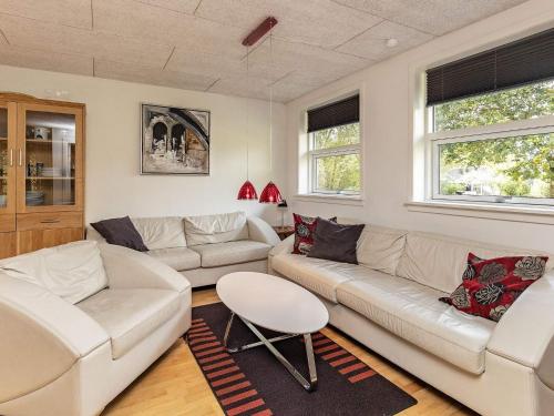 a living room with two couches and a table at 8 person holiday home in Skals in Skals