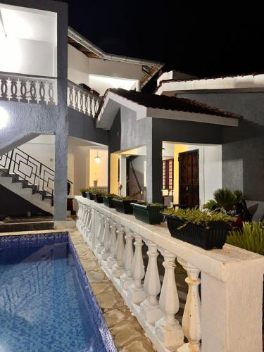 a house with a swimming pool next to a building at Honeydream Villa & Studio Apartments in Diani Beach
