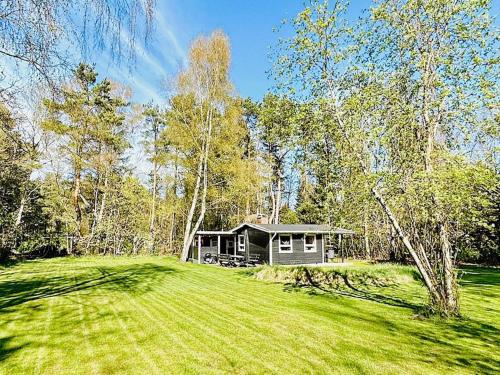 a small cabin in the middle of a grass field at 4 person holiday home in Frederiksværk in Frederiksværk
