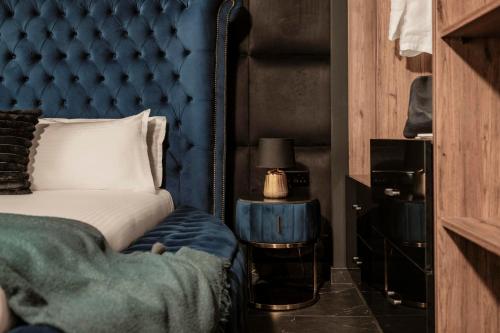 a bedroom with a blue headboard and a bed at Damare Resort & SPA in St Paul's Bay