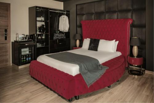 a bedroom with a large bed with a red headboard at Damare Resort & SPA in St Paul's Bay
