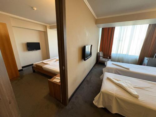 a hotel room with two beds and a mirror at N Royal Residence By Nairi in Yerevan