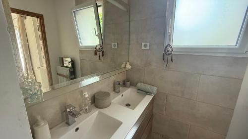 a white bathroom with a sink and a mirror at Maison d'hôtes du Realtor in Cabriès