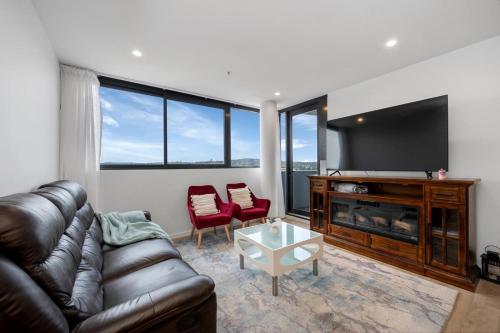 a living room with a couch and a flat screen tv at Three Bedroom Waterfall apartment in Weston Creek