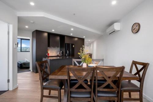 a kitchen and dining room with a wooden table and chairs at Three Bedroom Waterfall apartment in Weston Creek