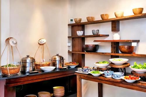 Una cocina con cuencos y ollas sobre una mesa. en Alagon City Hotel & Spa, en Ho Chi Minh