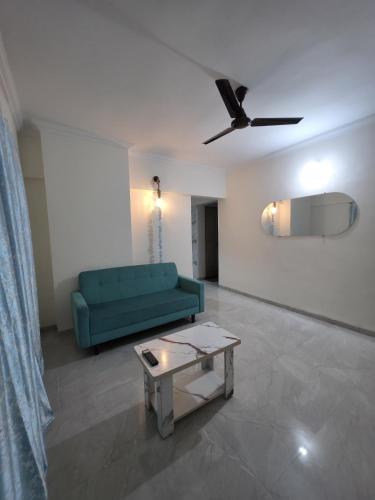 a living room with a green couch and a table at Pearl 2bhk Baner Balewadi Hinjewadi in Pune