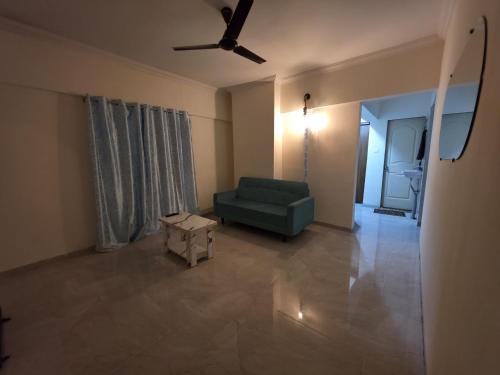 a living room with a green couch and a table at Pearl 2bhk Baner Balewadi Hinjewadi in Pune