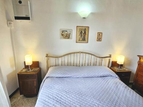 a bedroom with a bed and two night stands with lamps at Dimora dei Consoli in Gubbio