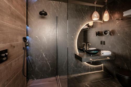 a bathroom with a shower with a sink and a mirror at Damare Resort & SPA in St Paul's Bay