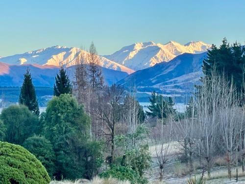 a mountain range with snow capped mountains in the distance at Mitchella Eco Stay in Wanaka