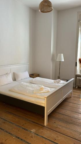 a large bed sitting on a wooden floor in a bedroom at Ostsee FeWo Lübeck in Lübeck