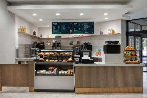 a bakery with a counter with bread and food at Dallas-Addison Marriott Quorum by the Galleria in Addison