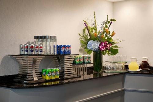 a counter with a vase of flowers and drinks at Dallas-Addison Marriott Quorum by the Galleria in Addison