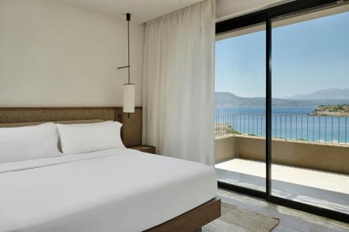 a bedroom with a bed and a view of the ocean at JW Marriott Crete Resort & Spa in Marathi