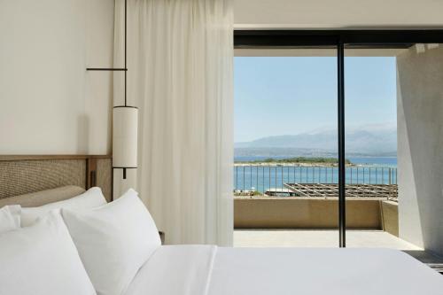 a bedroom with a bed and a view of the ocean at JW Marriott Crete Resort & Spa in Marathi
