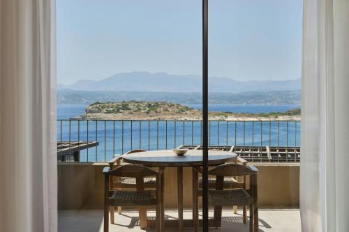 a table and chairs on a balcony with a view of the ocean at JW Marriott Crete Resort & Spa in Marathi