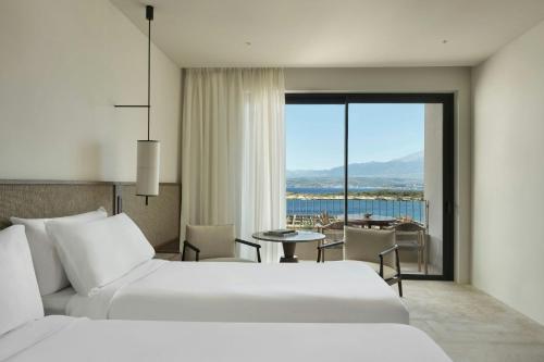 a hotel room with two beds and a view of the ocean at JW Marriott Crete Resort & Spa in Marathi