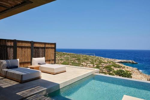 a villa with a swimming pool and the ocean at JW Marriott Crete Resort & Spa in Marathi