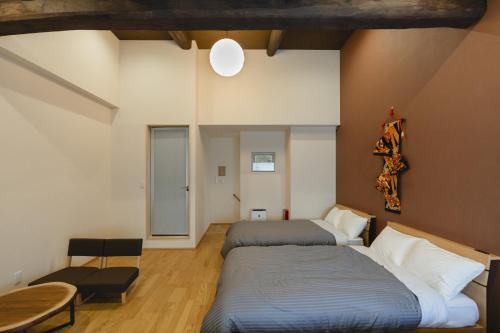 a bedroom with two beds and a table at 喜々Kiki in Miyazu