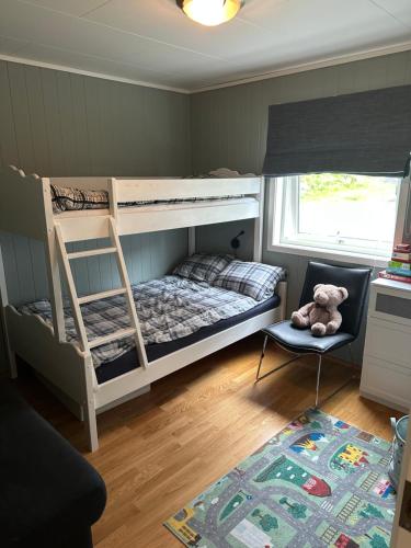 a bedroom with bunk beds with a teddy bear in a chair at Family-friendly apartment on the 1st floor in Bergset