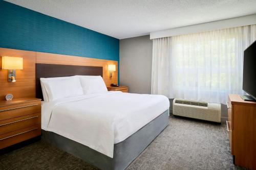 a hotel room with a large bed and a television at TownePlace Suites by Marriott Mississauga-Airport Corporate Centre in Mississauga