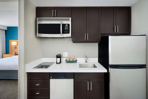 a kitchen with a sink and a microwave and a refrigerator at TownePlace Suites by Marriott Mississauga-Airport Corporate Centre in Mississauga