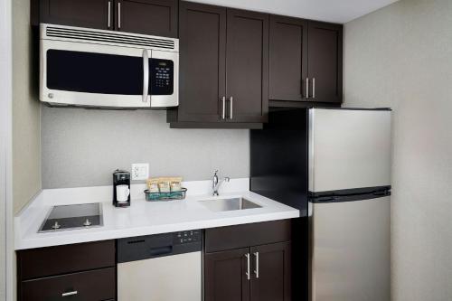 a kitchen with a sink and a microwave and a refrigerator at TownePlace Suites by Marriott Mississauga-Airport Corporate Centre in Mississauga