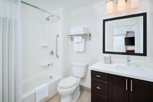 a bathroom with a toilet and a sink and a mirror at TownePlace Suites by Marriott Mississauga-Airport Corporate Centre in Mississauga