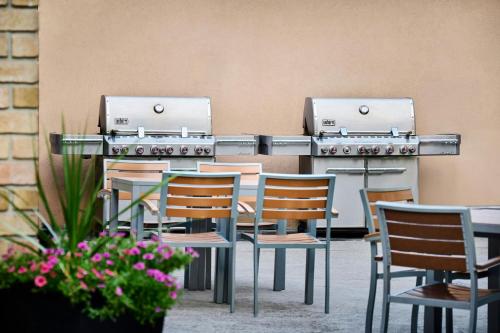 a restaurant with tables and chairs and two burners at TownePlace Suites by Marriott Mississauga-Airport Corporate Centre in Mississauga