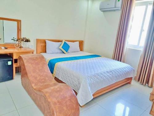 ブンタウにあるAn Khang Hotel Vung tauのベッドと机と鏡のある寝室