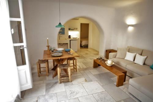 a living room with a table and a couch at Mykonos Moussa in Agios Ioannis Mykonos