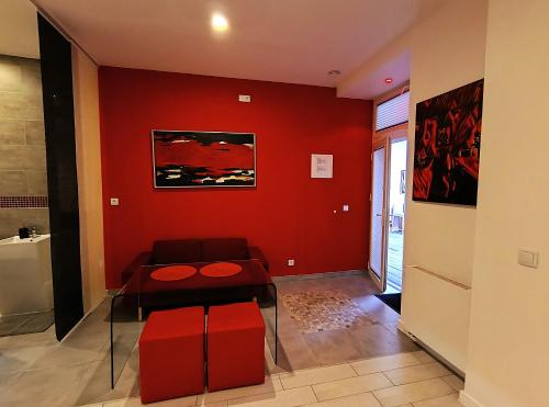 a red living room with a bench and a table at Mirror Apartments in Kraków