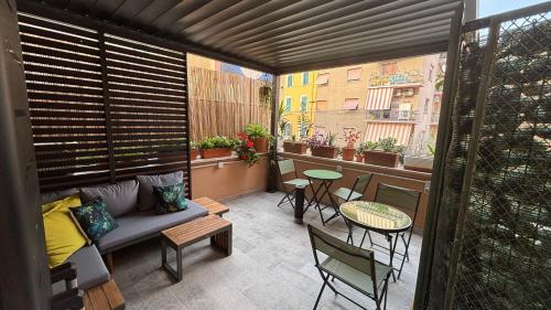 a balcony with a couch and a table and chairs at La Dolce Vita Civitavecchia in Civitavecchia