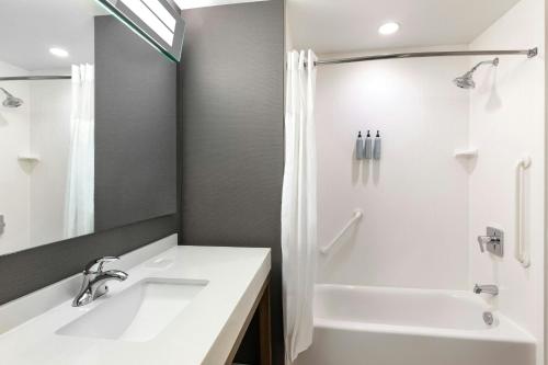 a bathroom with a sink and a tub and a shower at Courtyard by Marriott St. Louis St. Peters in Saint Peters