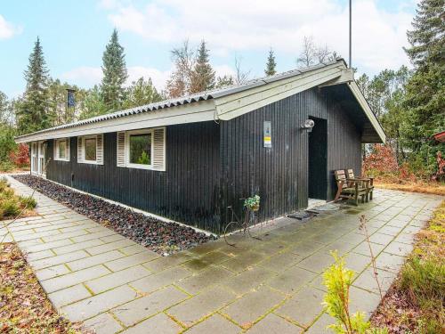 a black building with a patio in front of it at 5 person holiday home in Herning-By Traum in Kølkær
