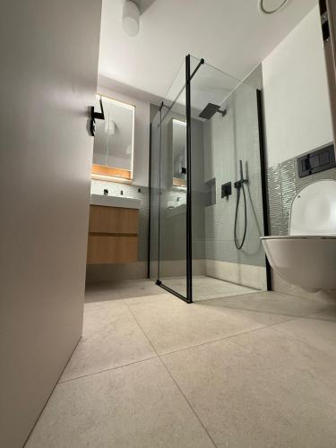 a bathroom with a shower and a tub and a sink at Chata Milde in Nový Hrozenkov
