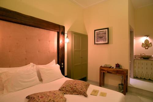 a bedroom with a bed with a wooden headboard and a table at 1901 Hermoupolis in Ermoupoli