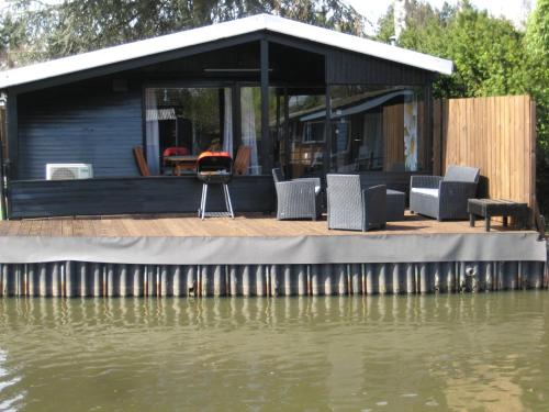 a house on a dock next to a body of water at Modern waterfront chalet in Geel
