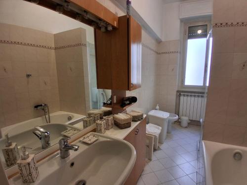 a bathroom with a sink and a tub and a toilet at Central Art House in Como