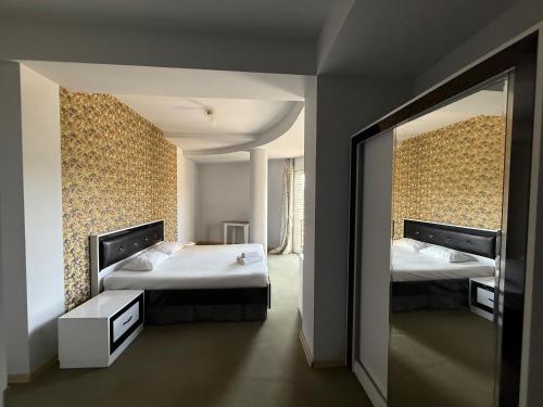 Stantsiya MukhianiにあるHotel Batoniのベッド2台と大きな鏡のある寝室