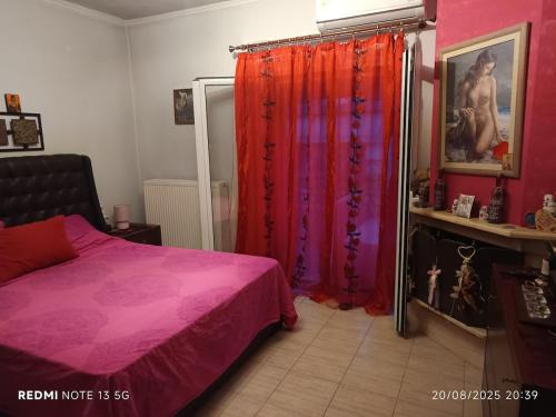 a bedroom with a pink bed and red curtains at Διαμέρισμα Μαρία in Kalabaka