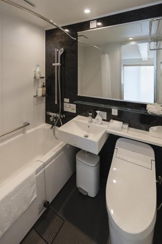 a bathroom with a toilet and a sink and a bath tub at 喜々Kiki in Miyazu